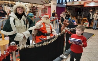 Alan Myatt handing out Christmas presents as Deluxe Father Christmas